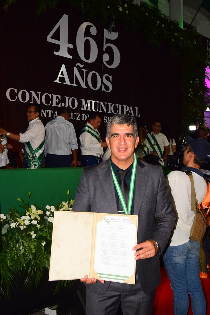 PhD. Marcelo Rodrigo Vasquez Lema sostiene el reconocimiento al Mérito Municipal otorgado por el Concejo Municipal de Santa Cruz de la Sierra